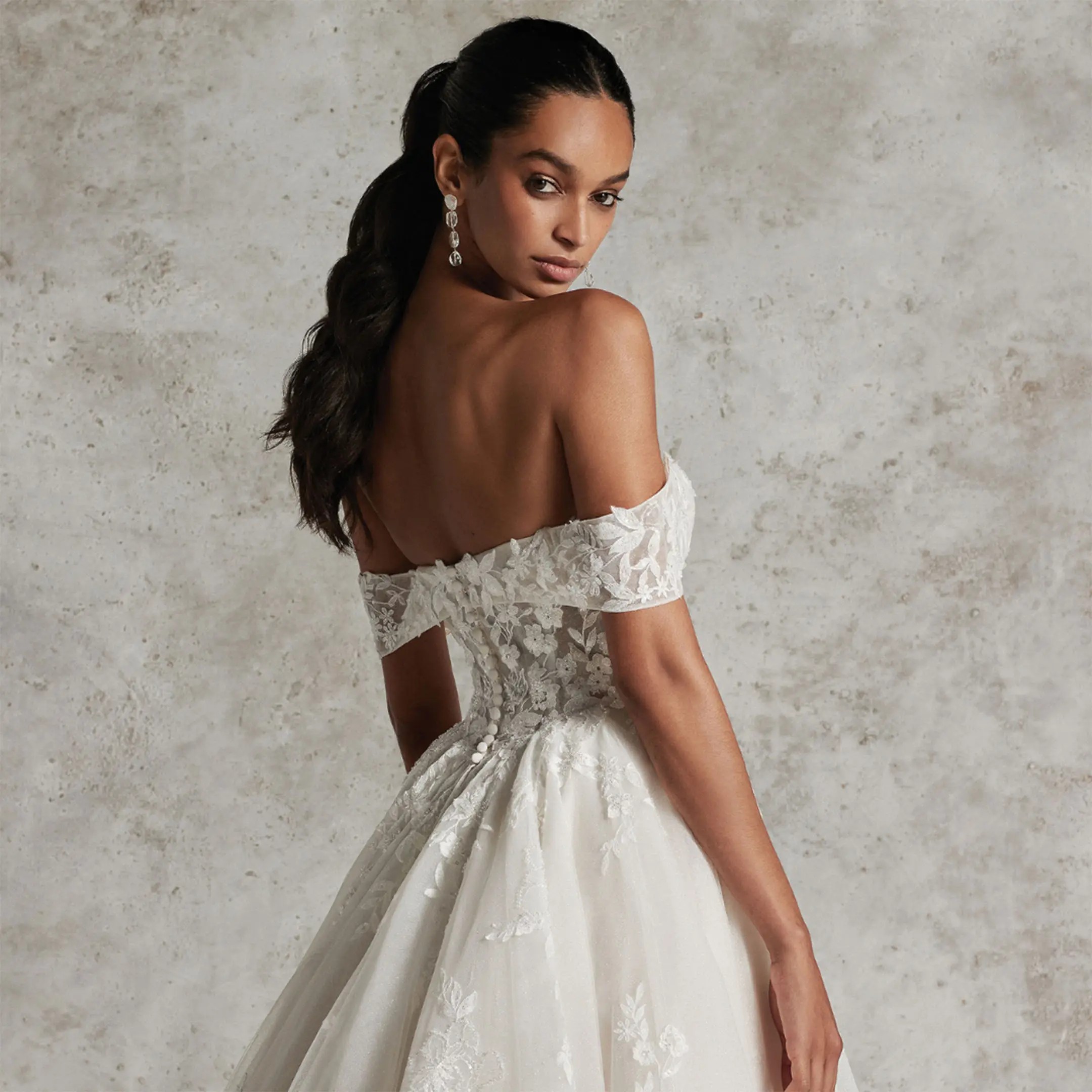 Model wearing white off the shoulder ballgown dress